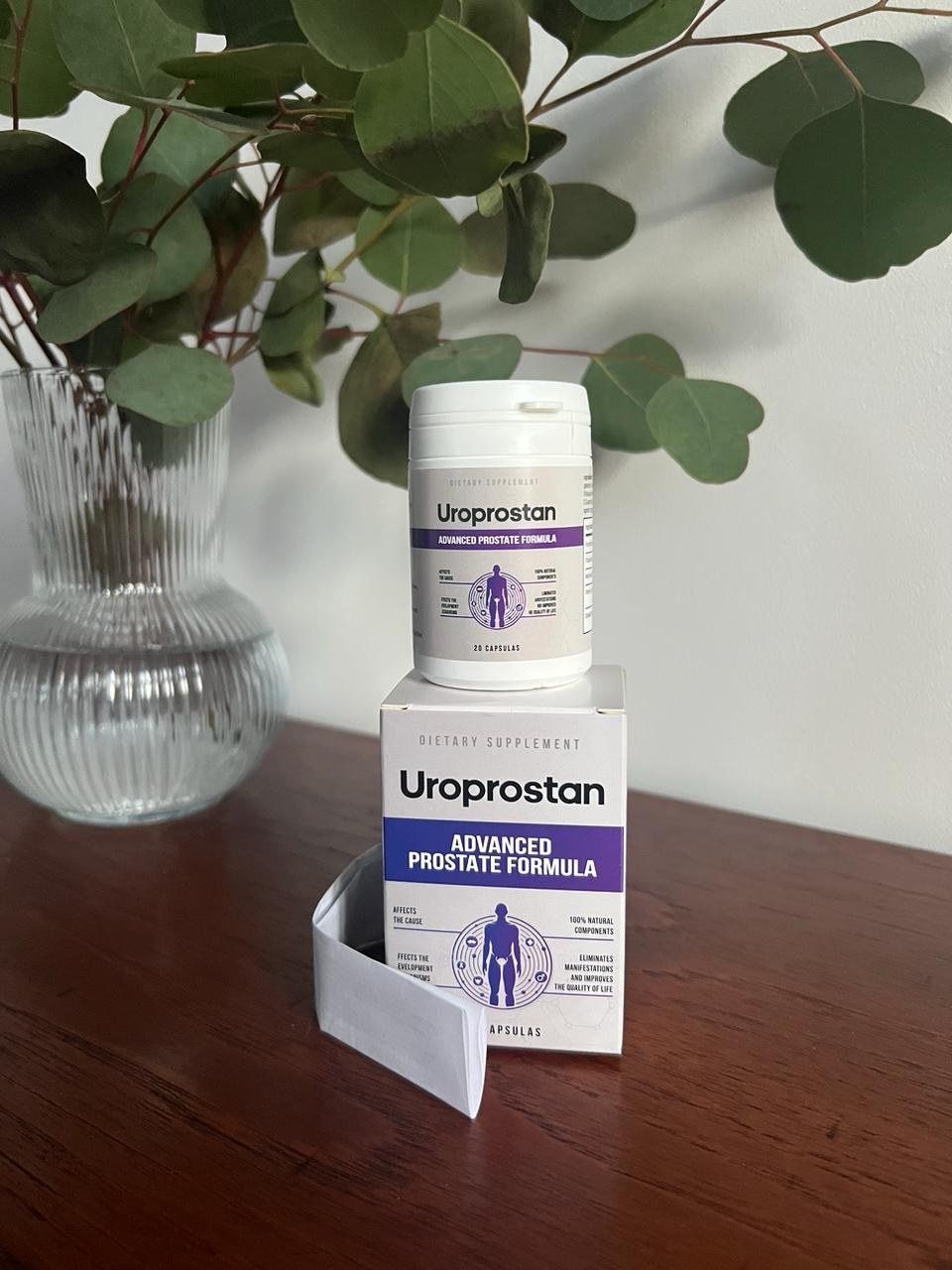 Bote y caja de Uroprostan sobre una mesa de madera, junto a una planta